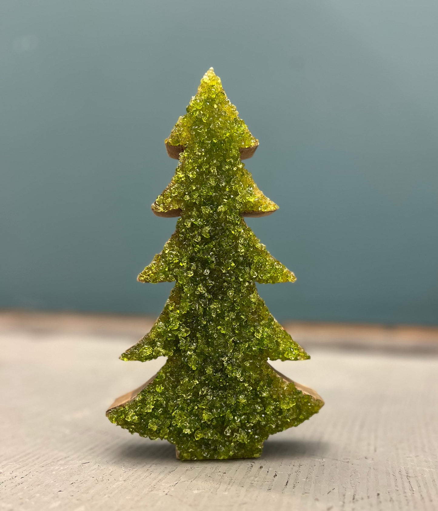 Green textured Christmas tree figurine on a neutral background